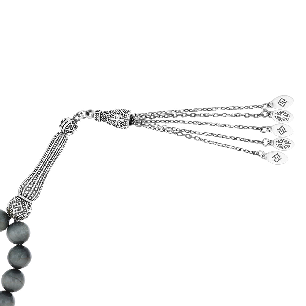 Close-up of Rosary eagle eye showing silver accents and natural tiger’s eye beads with ornate tassel design.