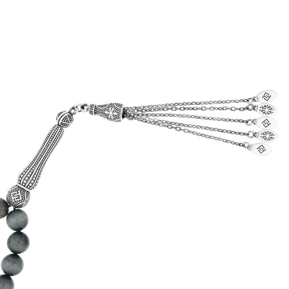 Close-up of Rosary eagle eye showing silver accents and natural tiger’s eye beads with ornate tassel design.